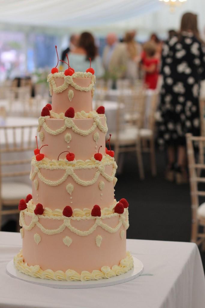 Pink vintage wedding cake at an outdoor marquee reception