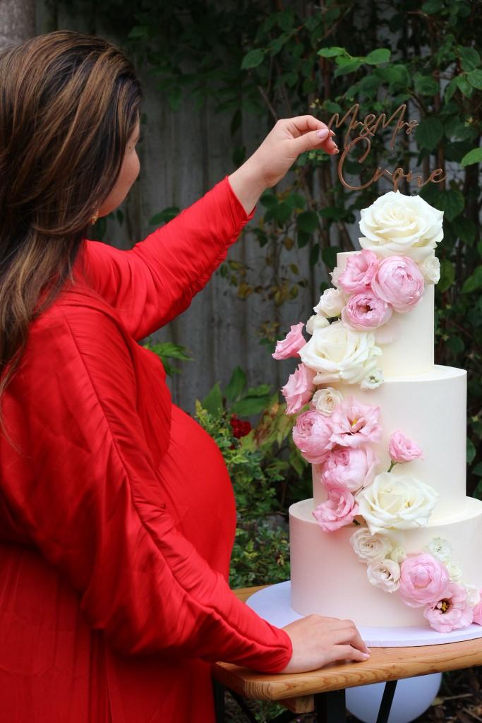 Bold mustard-toned wedding cake with vibrant wildflower cascade