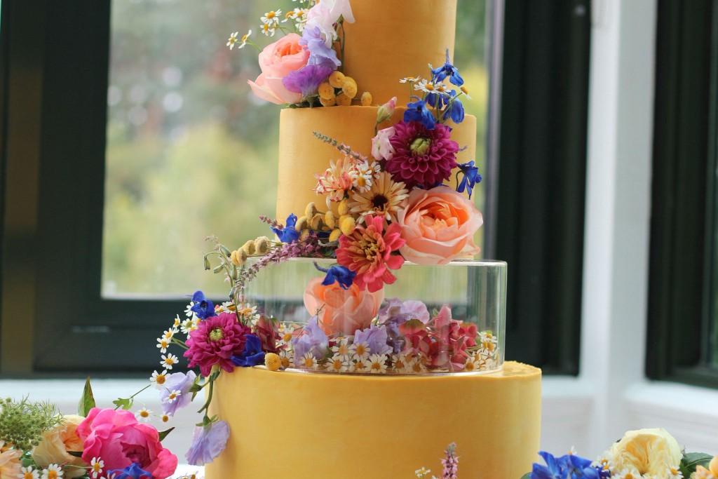 Heart-shaped wedding cake with a wooden Mr & Mrs stand